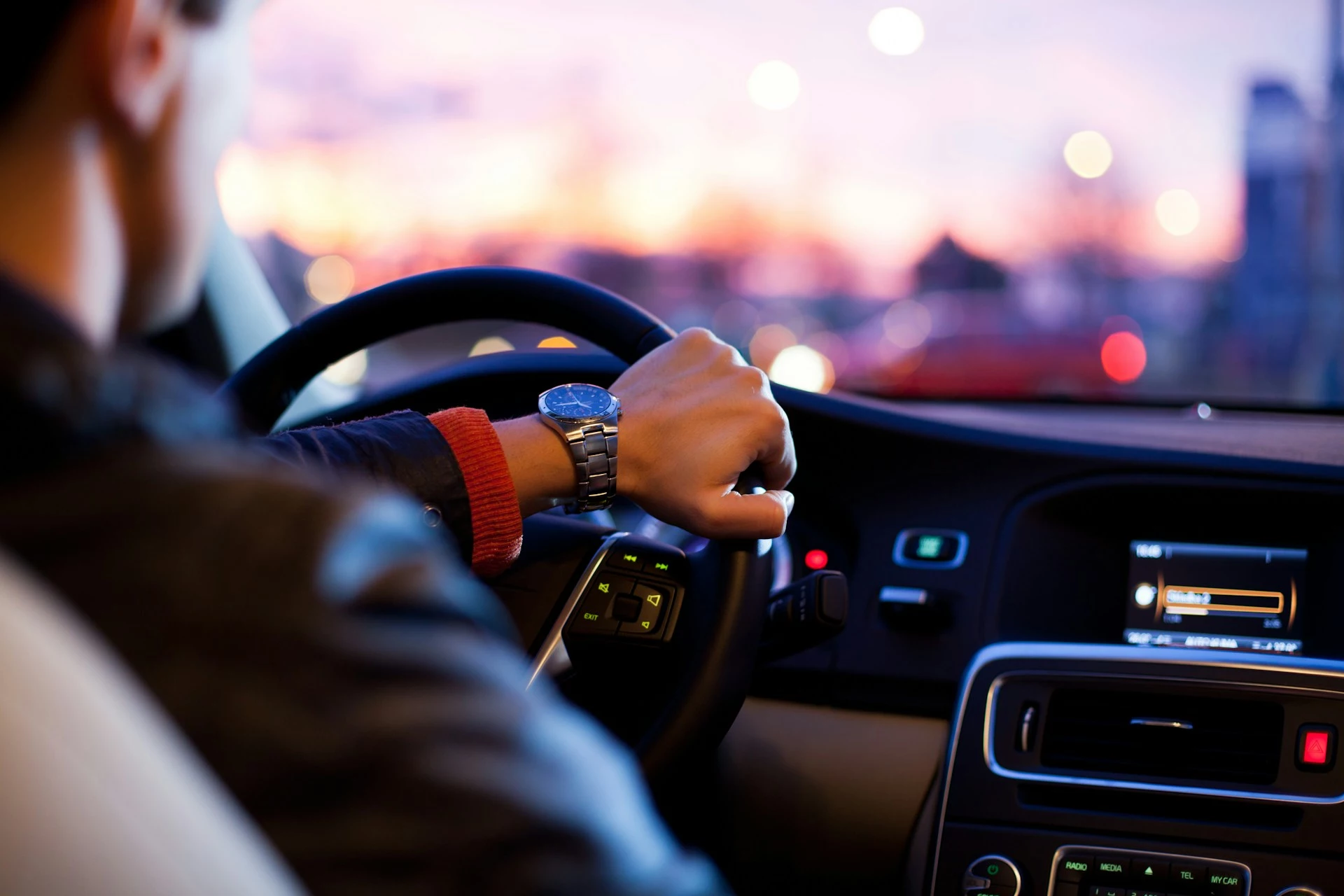Chauffeur driving through the city at dusk