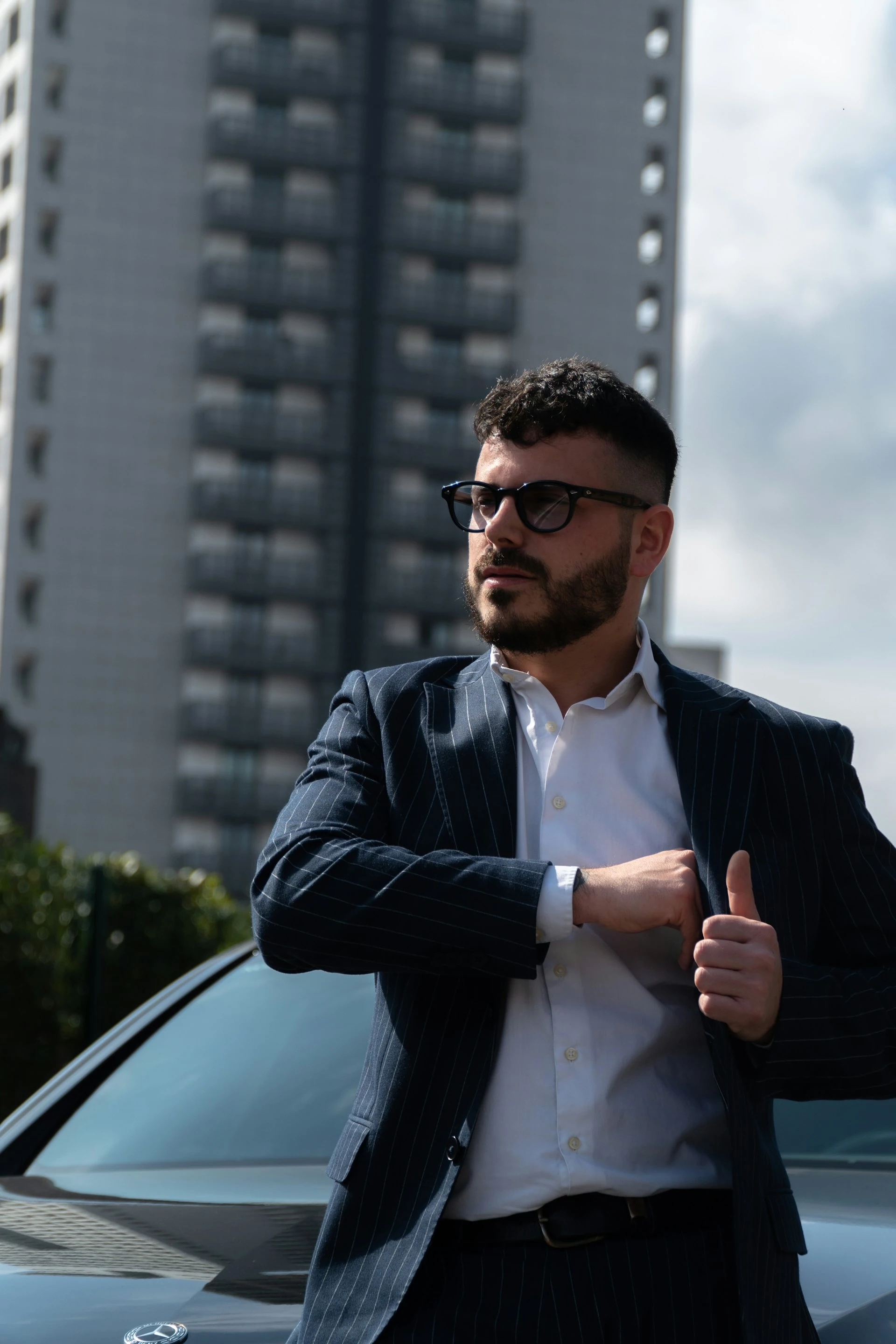 Well-dressed Driviance chauffeur beside a Mercedes